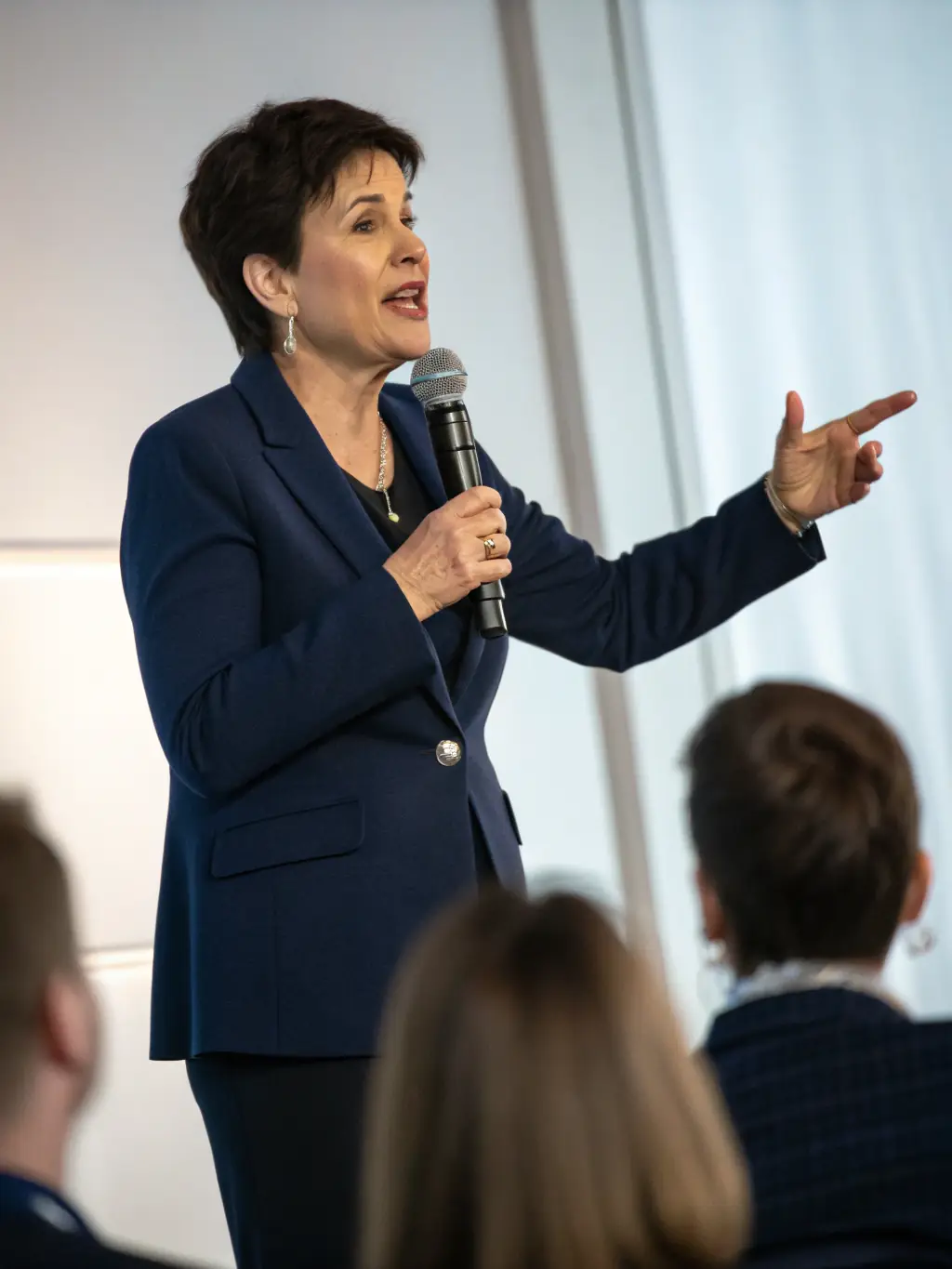 A photograph capturing a keynote speaker passionately addressing a large audience at a versionrh conference, emphasizing engagement and knowledge sharing.